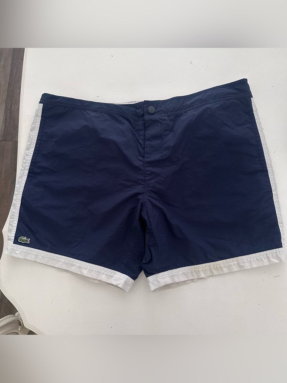 Lacoste swim trunks featuring a navy blue design w/ white panel crocodile logo